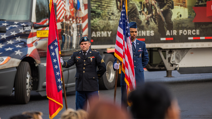 military members holding flags at veterans day event